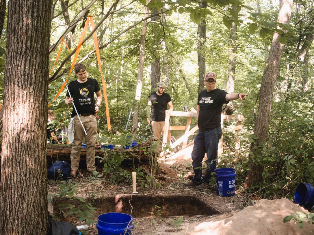 Students stand at a dig site during field school