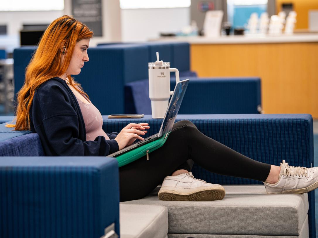 A student working on her laptop in the library.