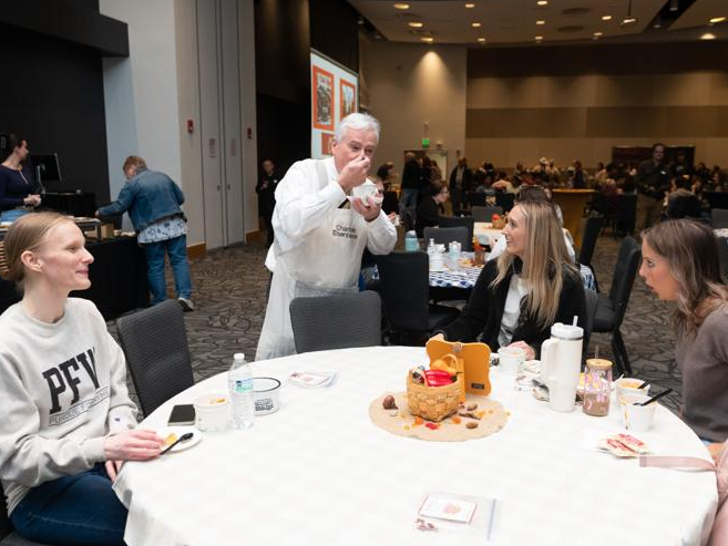Chancellor Ron Elsenbaumer is visiting with students at a table