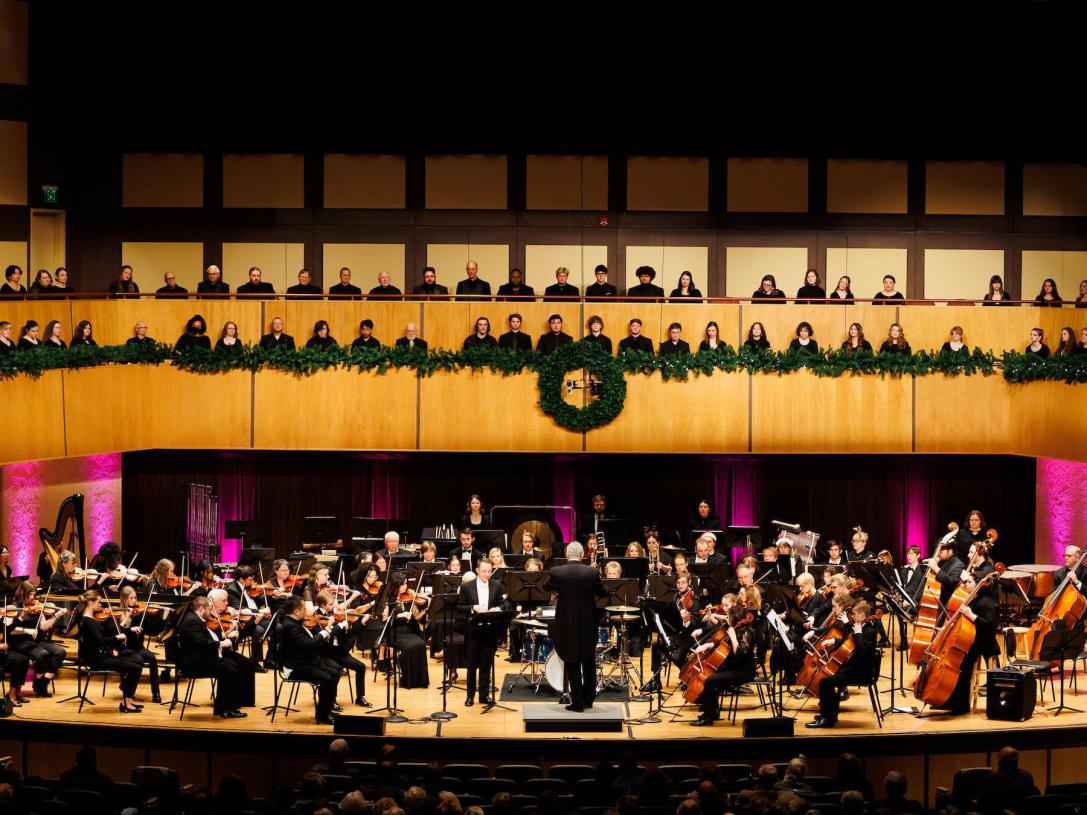 Choirs and an orchestra on stage at a holiday concert
