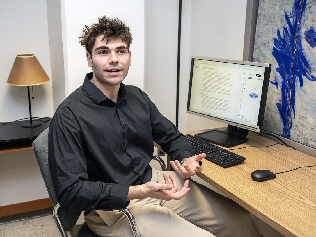 Hayden Crowell is sitting at a desk