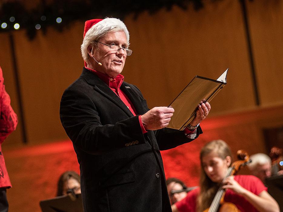 John O'Connell is reading narration at an orchestra holiday concert.