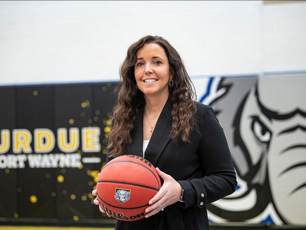 Coach Maria Marchesano is holding a basketball