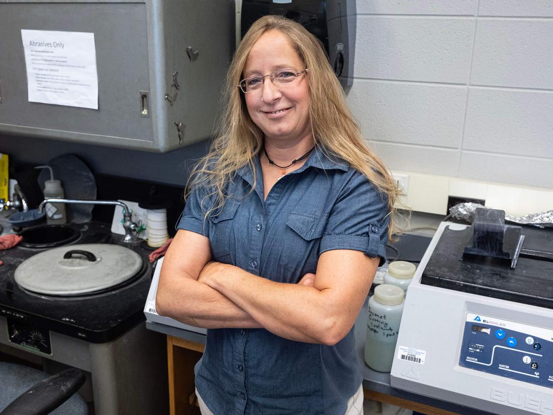Jackie Miller is in a lab with her arms crossed