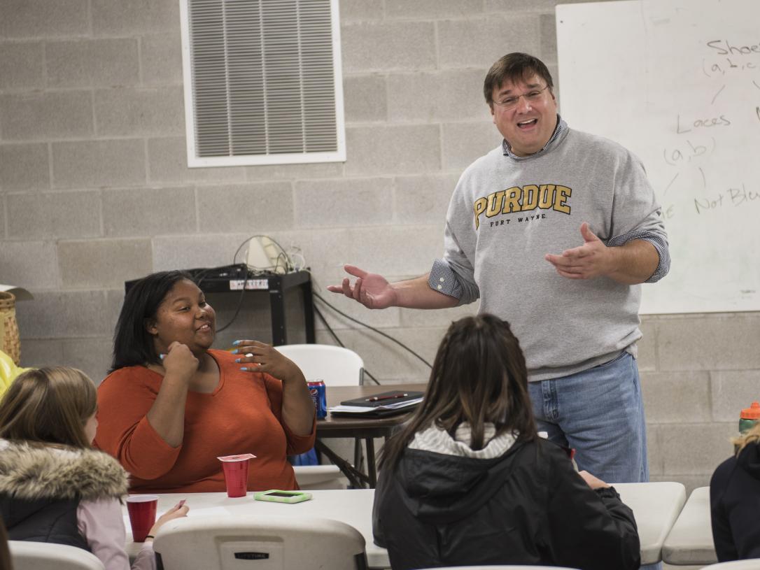 Professor giving presentation to younger students
