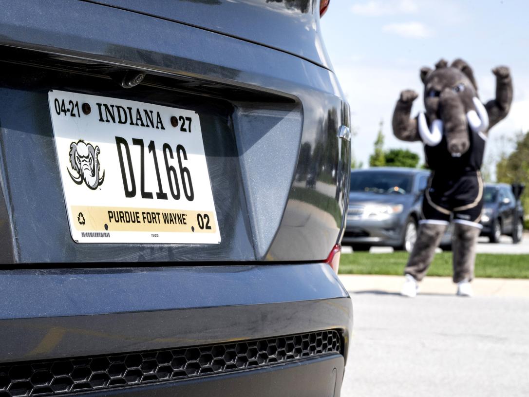 Don poses next to a car with a PFW license plate