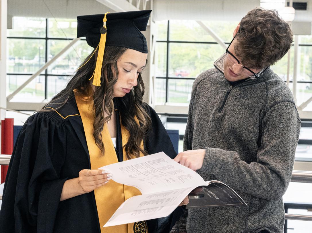 Two students prepare for the 2026 commencement ceremony