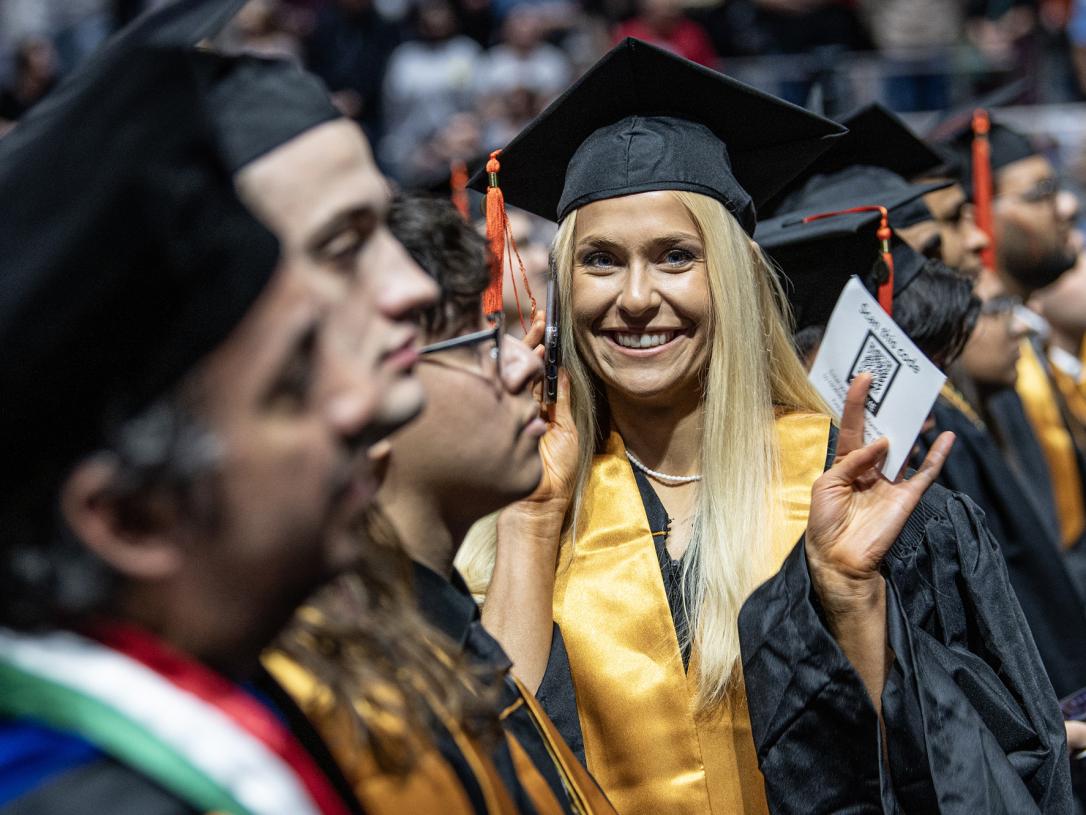 Student waves during the 2026 commencement ceremony