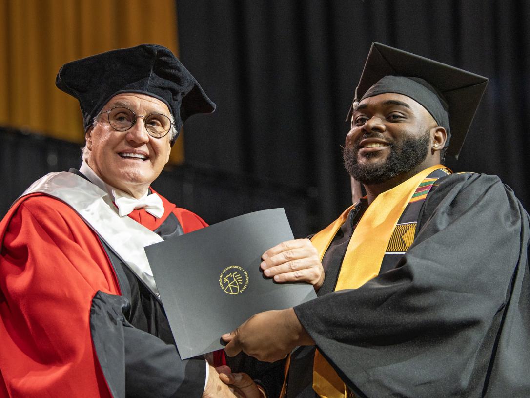 A student recieves a degree on the commencement stage