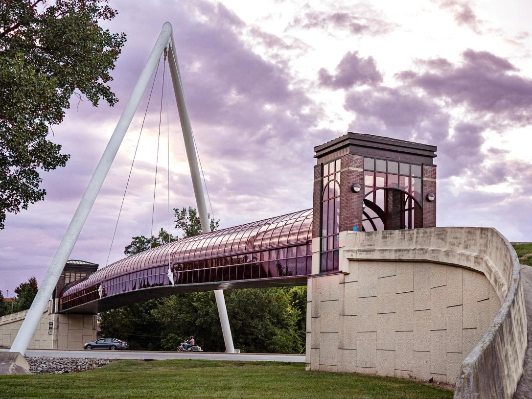 Students are walking across Wolf Bridge at sunset