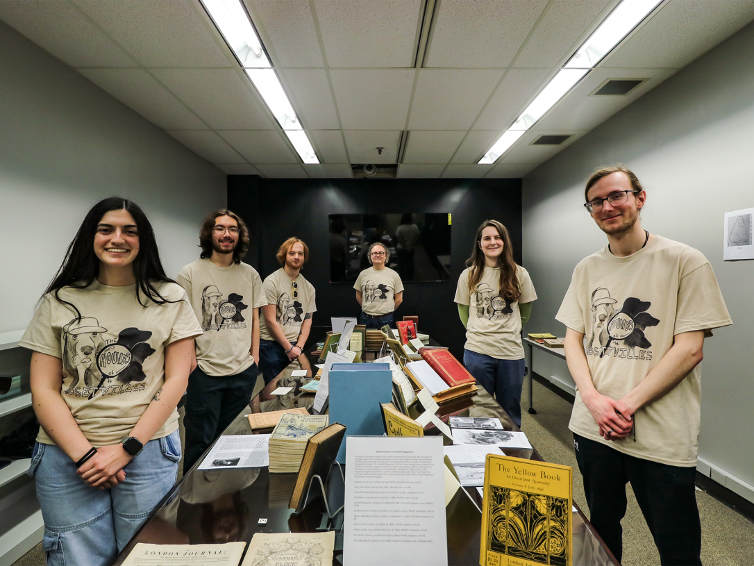 Victorian Co-Lab students and Dr. Bassett posing next to their exhibits