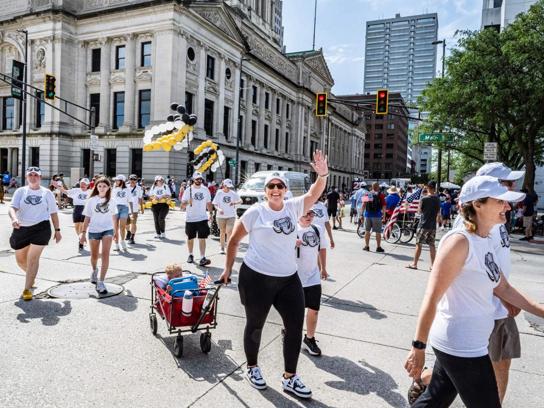 A participant is waving in a 4th of July parade