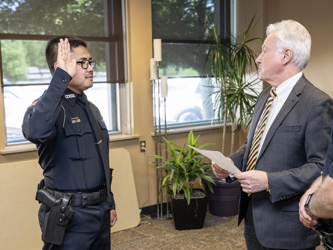 A police officer is being sworn in by the chancellor.