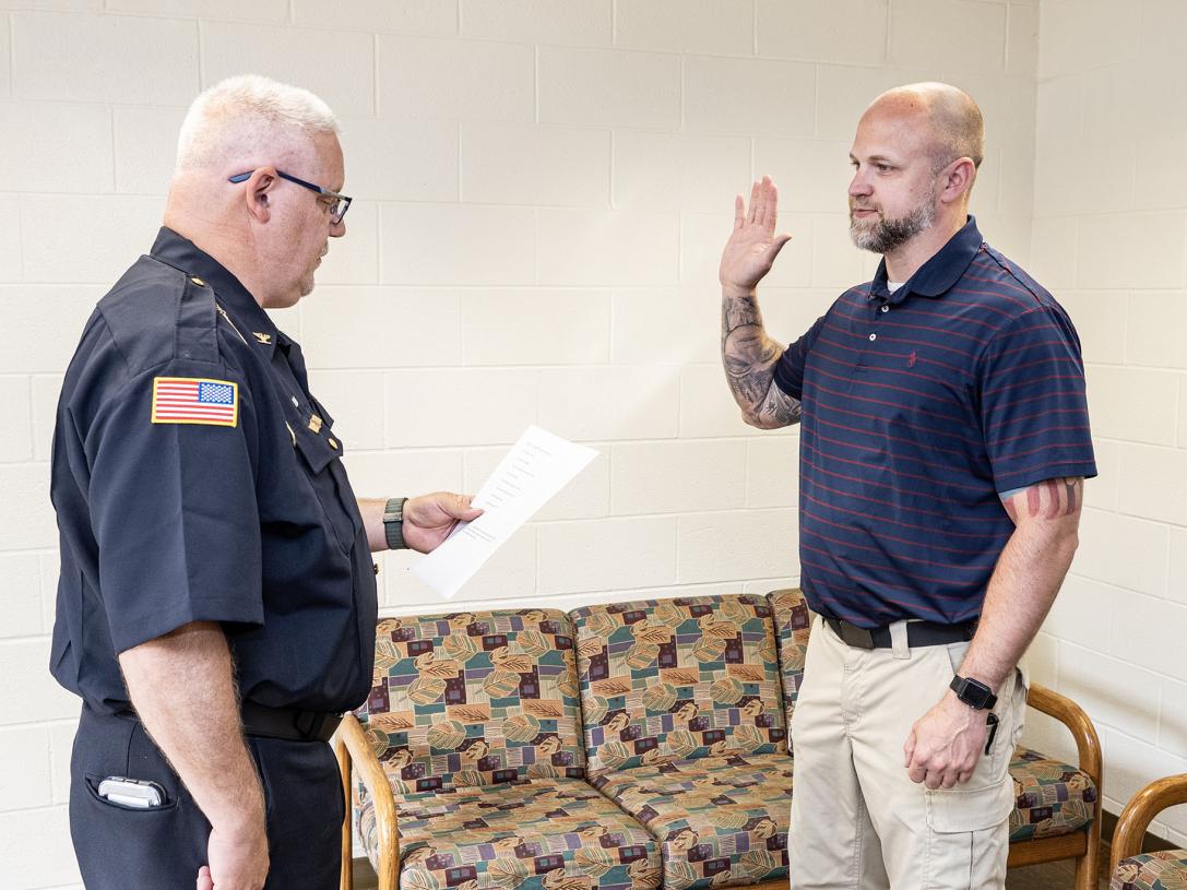 A police officer is being sworn in by the chief.
