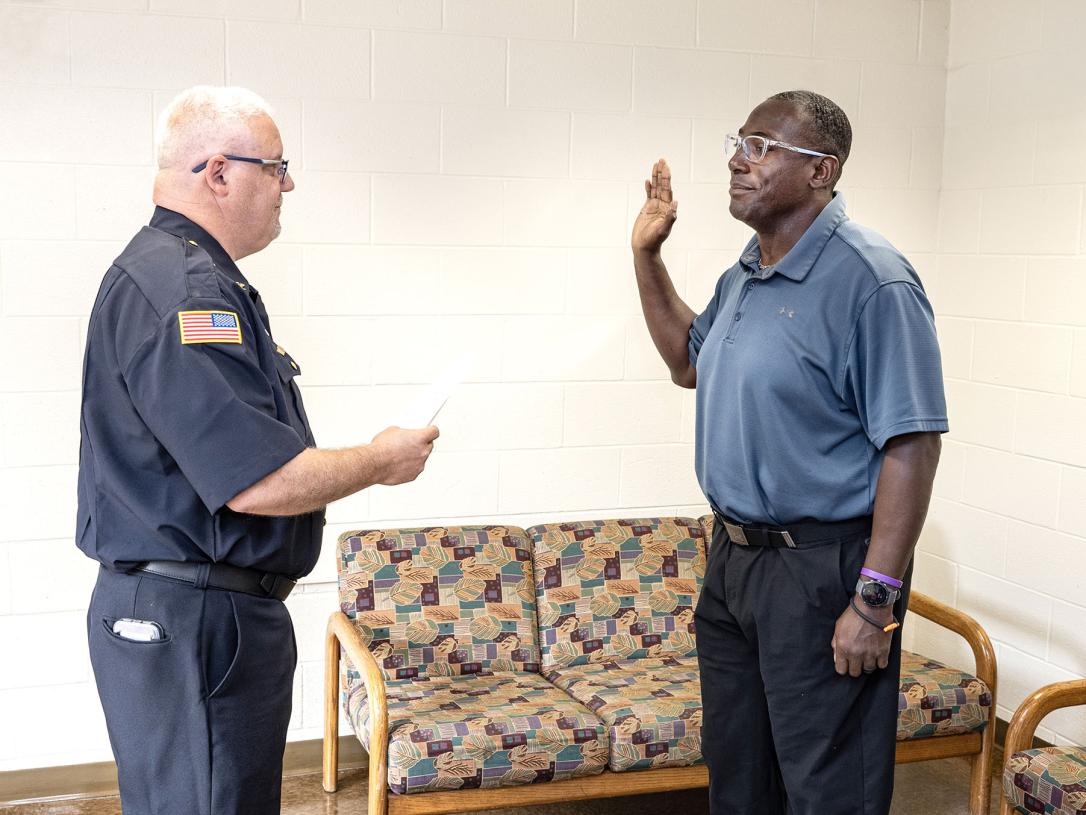A police officer is being sworn in by the chief.