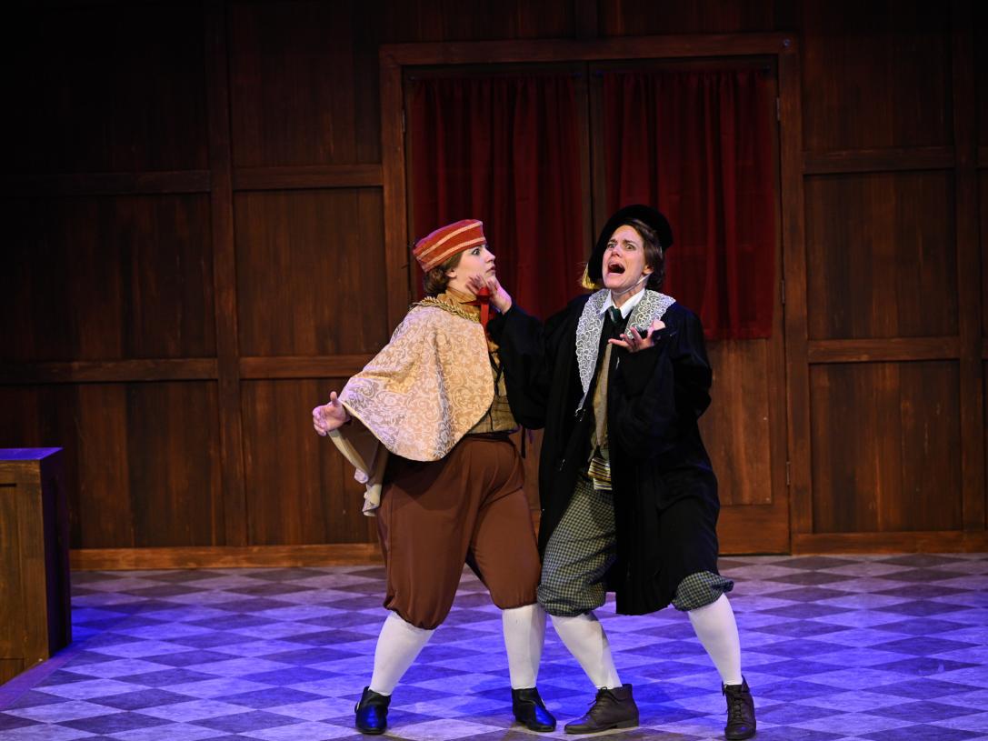 Two actors in shakespearean costumes, they appear to be in distress