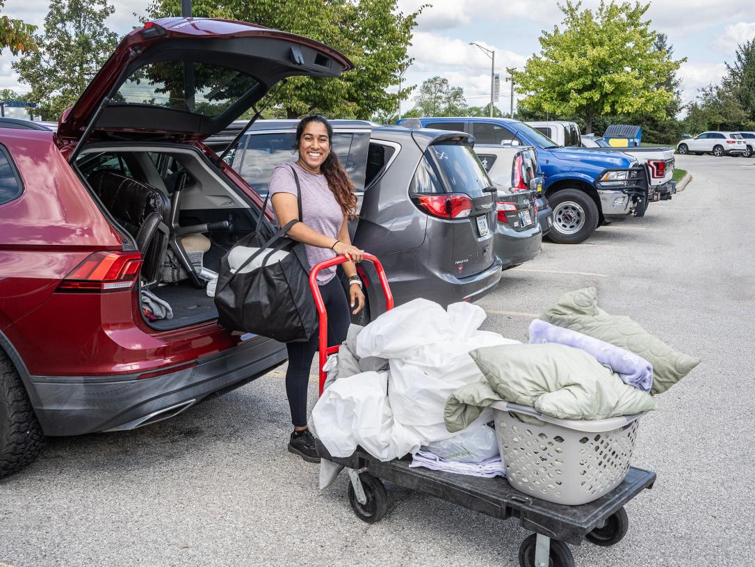 A student is moving personal items on a cart
