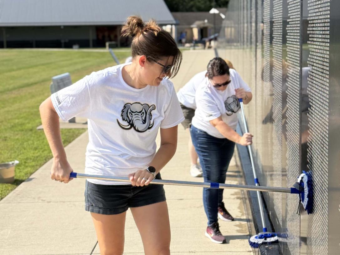 A volunteer is cleaning a veterans memorial