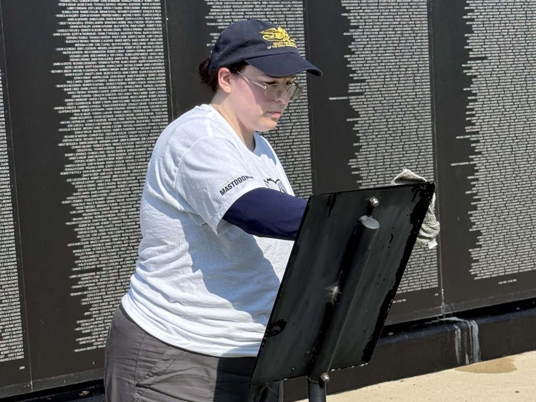 A volunteer is cleaning a plaque