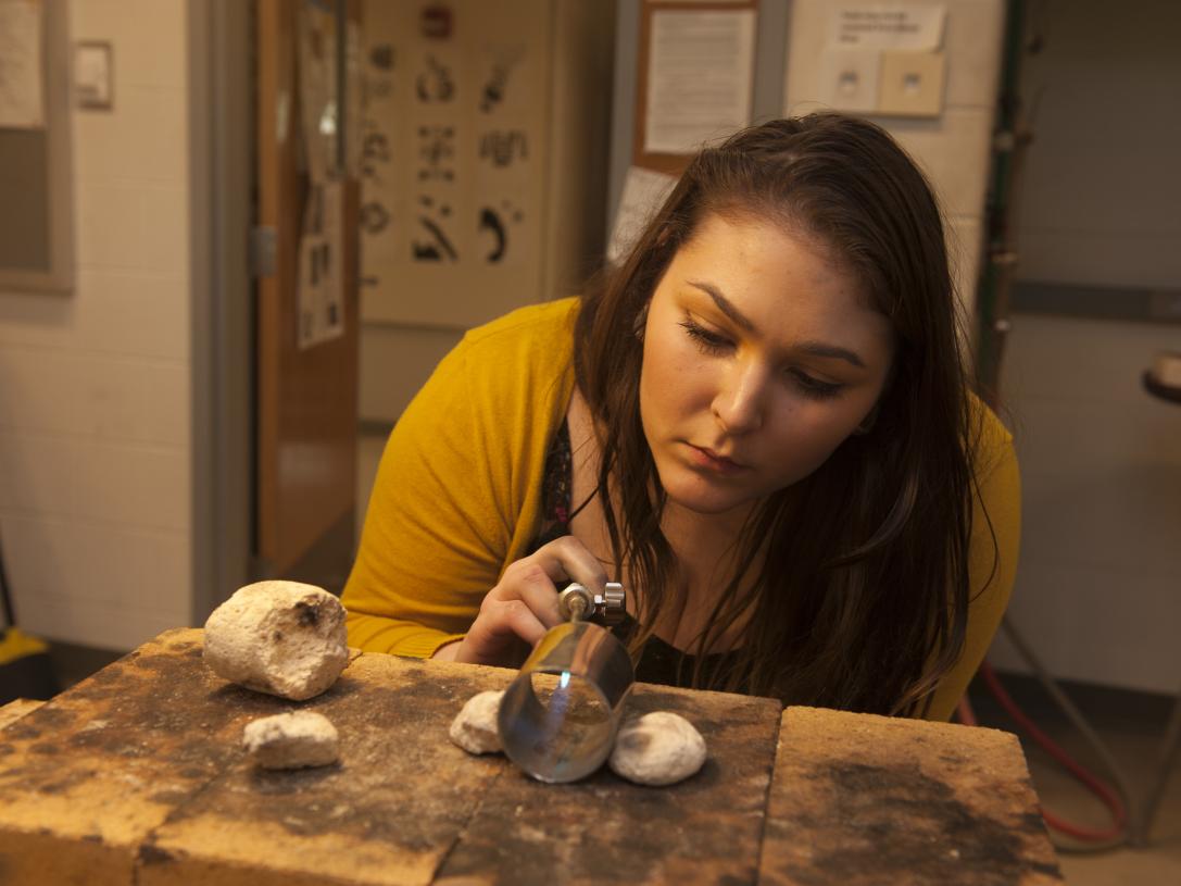 Female student working on a metal art project
