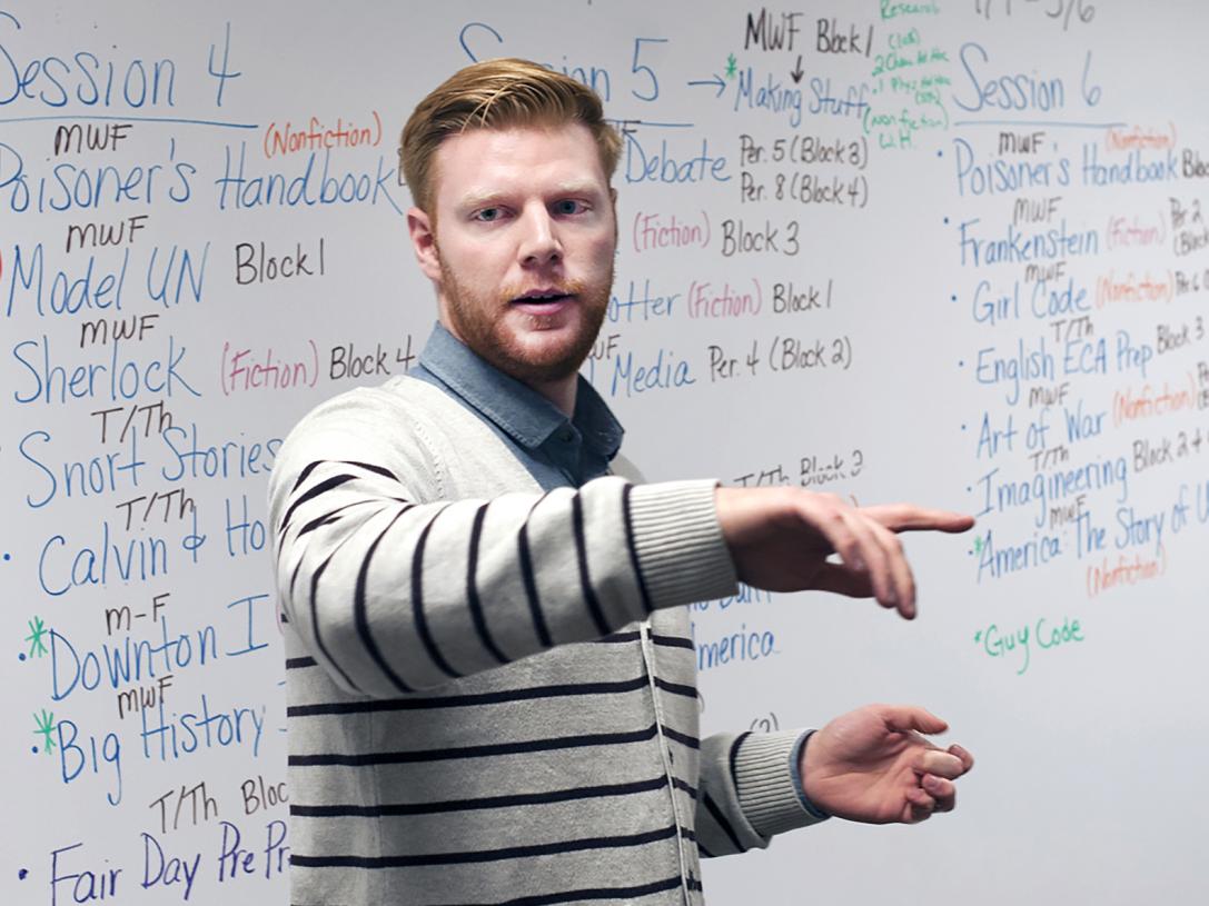A male teacher in front of a white board