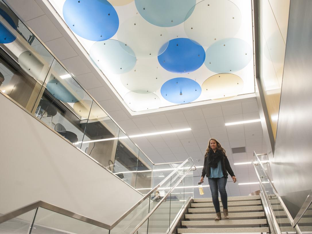 Helmke library where the student is descending the stairs from 2nd to 1st floor.
