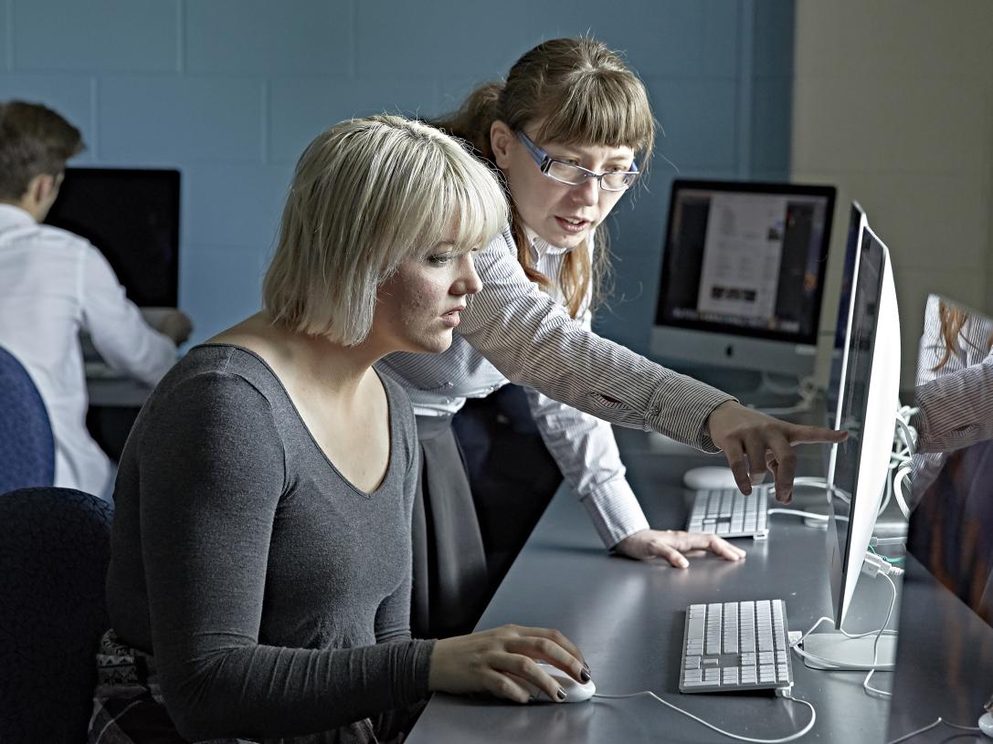 A faculty member instructs in Photoshop