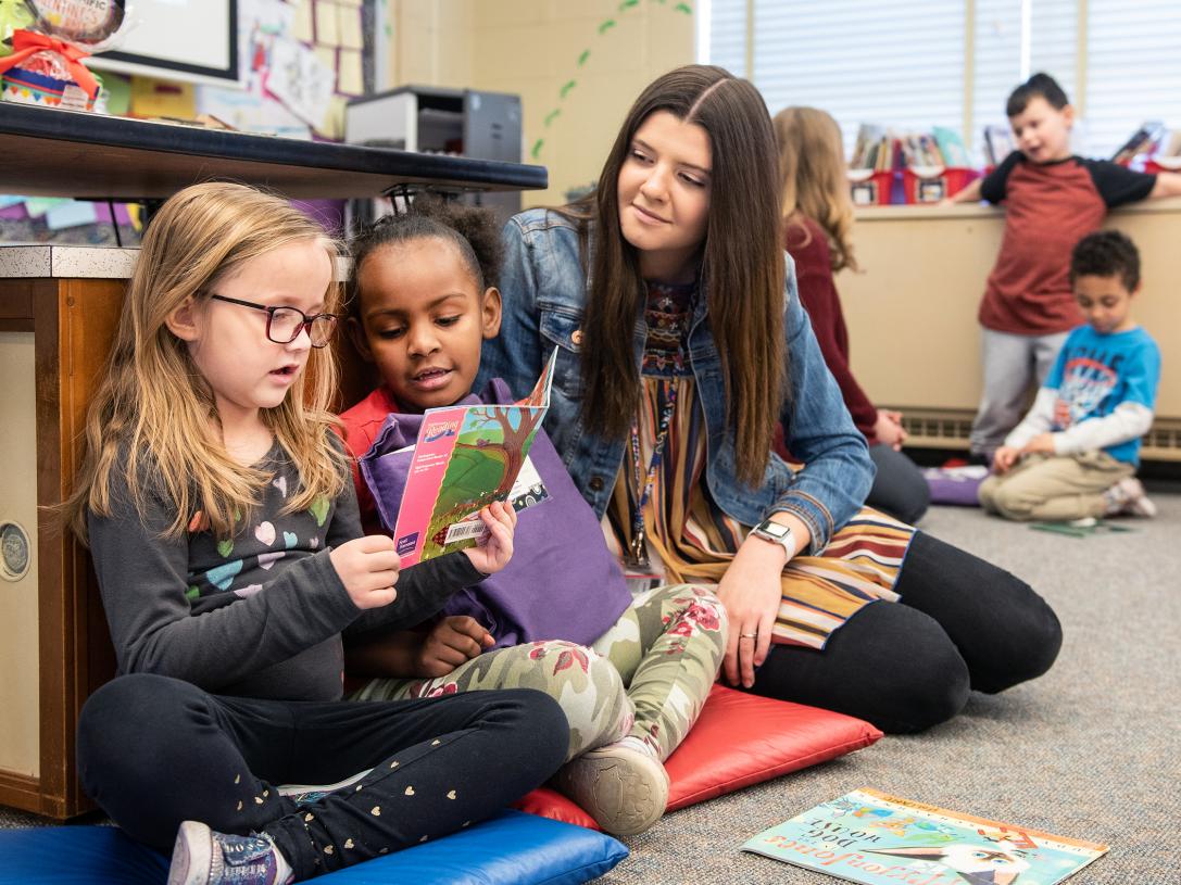 A student teacher reading with children