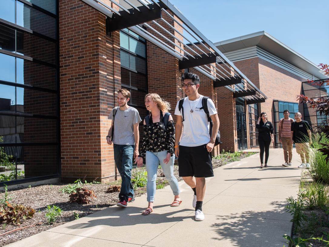 Students walking and discussing their class notes.