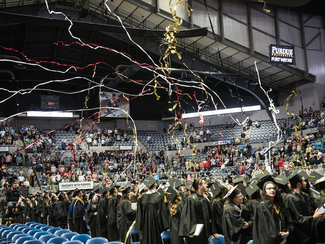 Joy and streamers fill the air at Memorial Coliseum during the most recent commencement ceremony for both universities.