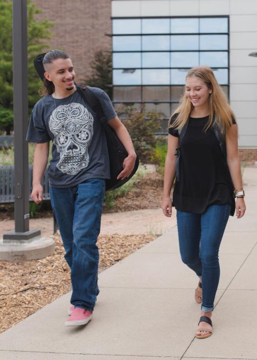 Students walking and discussing their class notes.