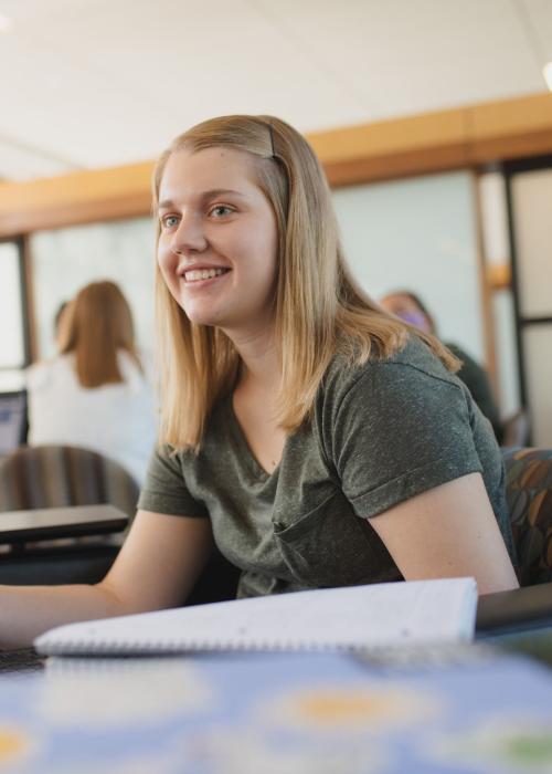 Female student sitting and studying indoors.