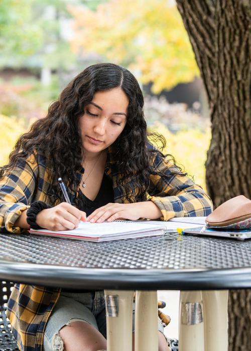 Student writing outdoors