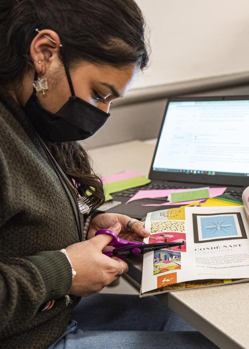 A student works on a collage in a gender studies class