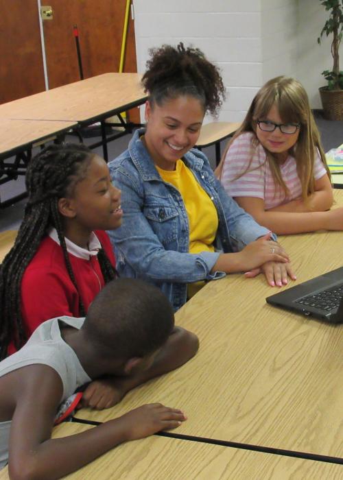 Student with children in a classroom.