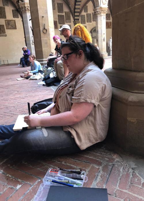 An art student is drawing outside