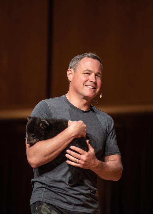 Jeff Corwin on stage with a cub.
