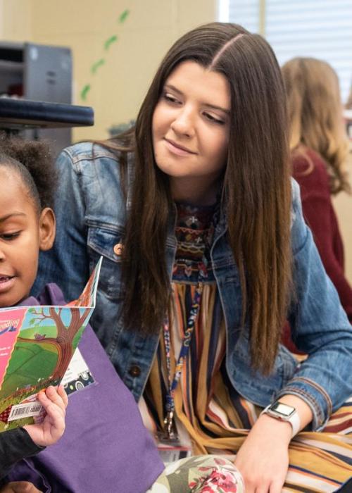 Student teacher reading with children.