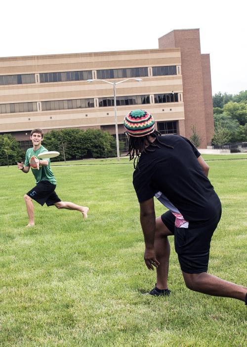 Students tossing a frisbee around in their free time.