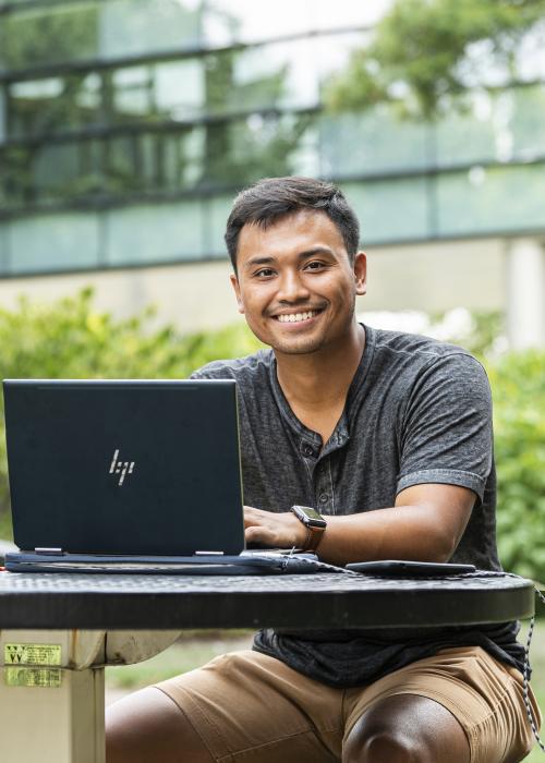 Student studying his class notes on his laptop.
