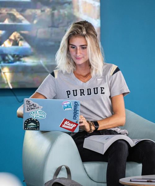 A female student studying in a library lounge