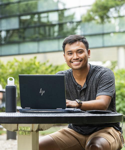 Student studying his class notes on his laptop.