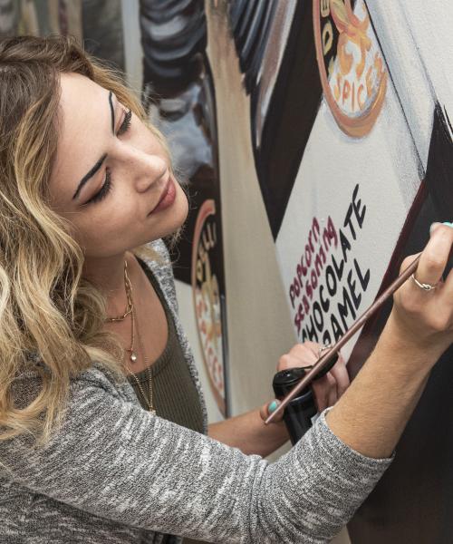 Samantha Fulk signs her completed mural at Dell Cove Spices and More in New Haven