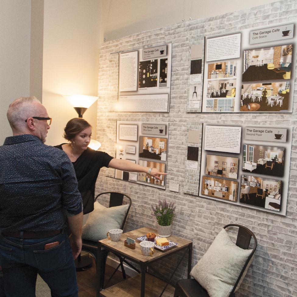 Interior design student talking to someone about their display