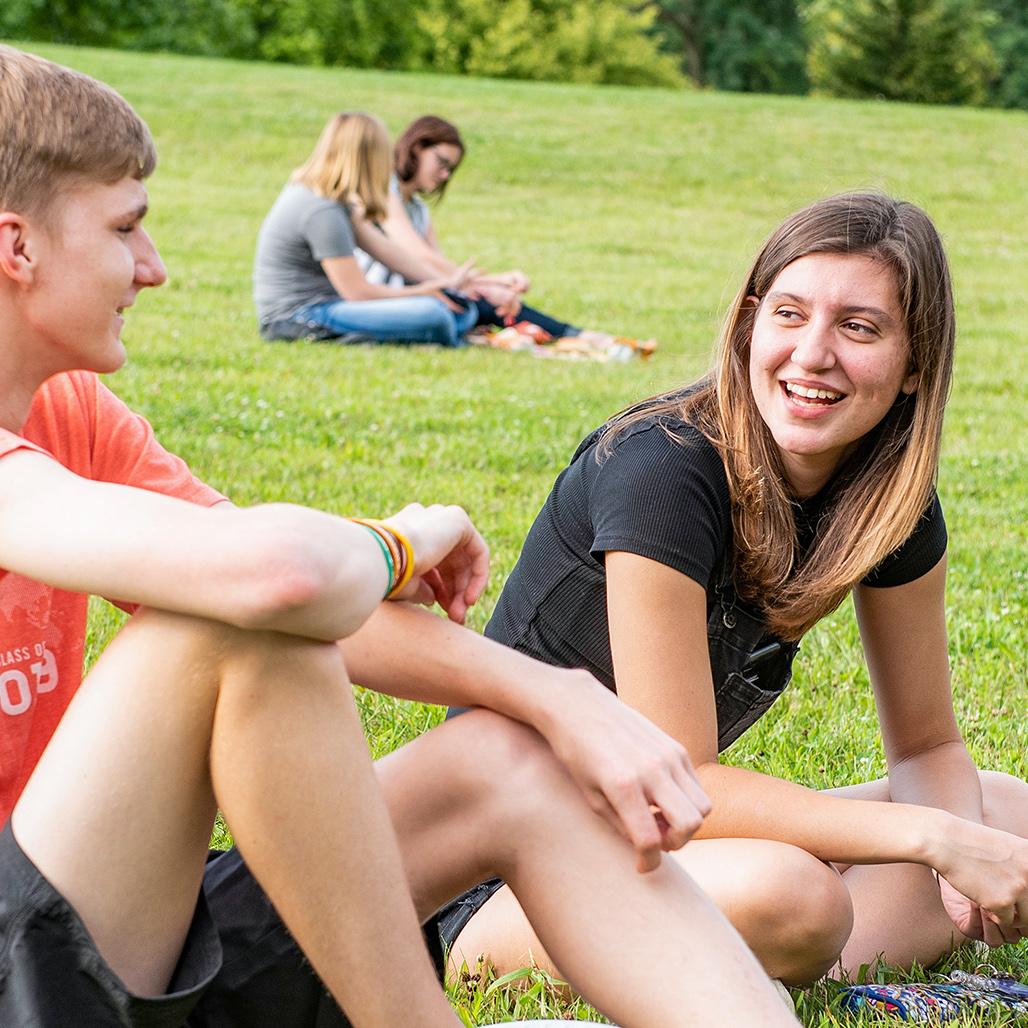 A couple sitting and talking on the VPA amphitheatre hill