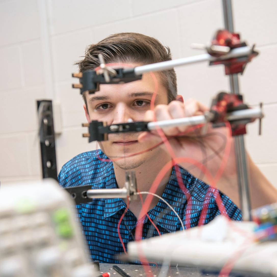 A physics student and his project in a lab
