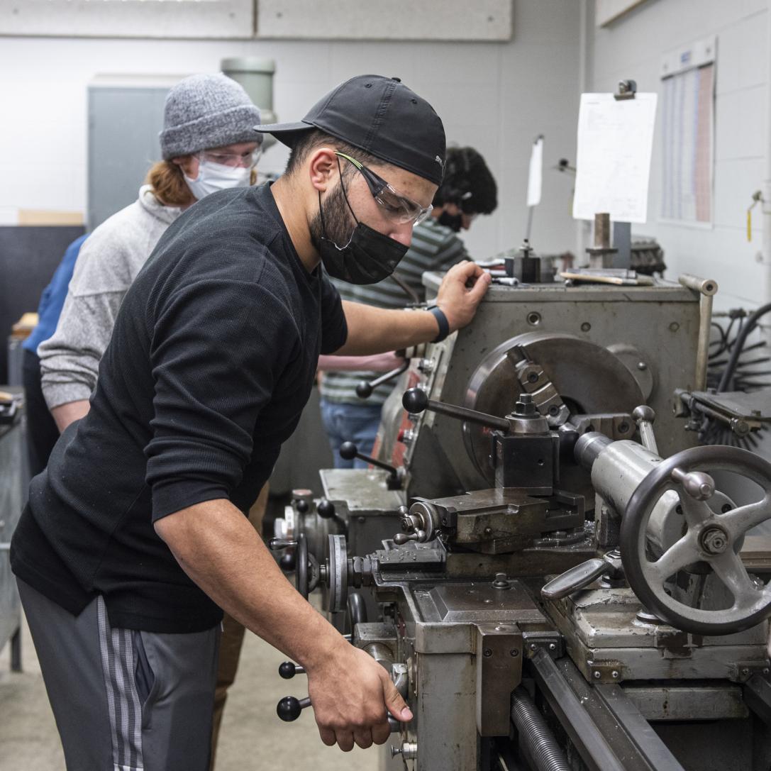 Students working with a lathe.