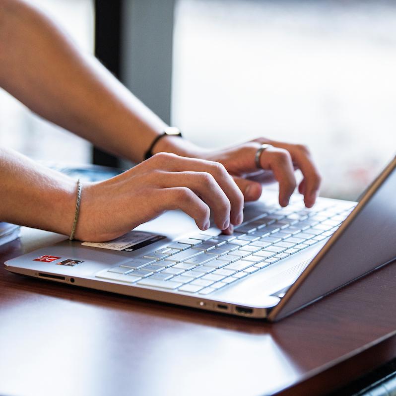 Student types on a laptop.