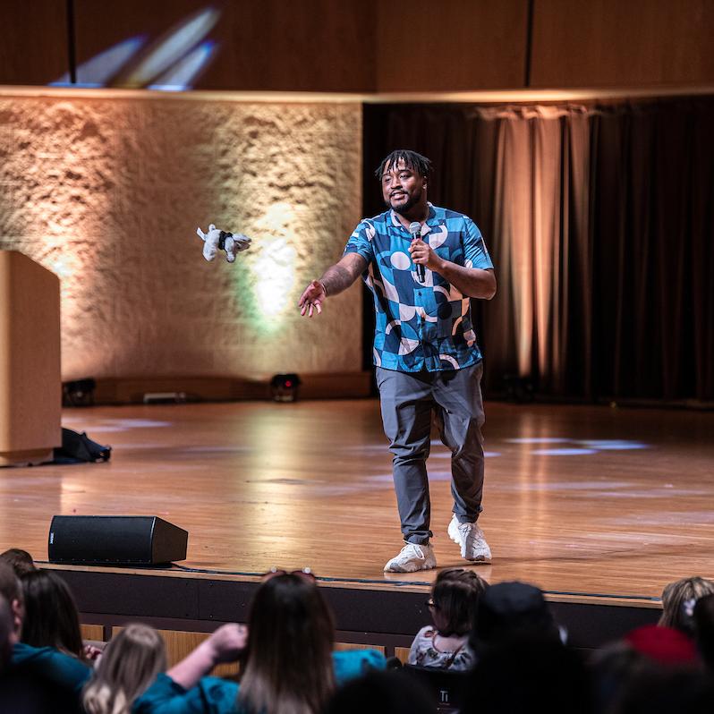 Ryan Meriwether tosses a toy mastodon to the audience during Admitted Student Day.