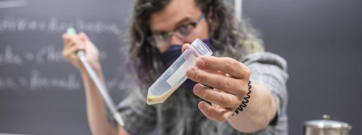 A Biology instructor examines a vial